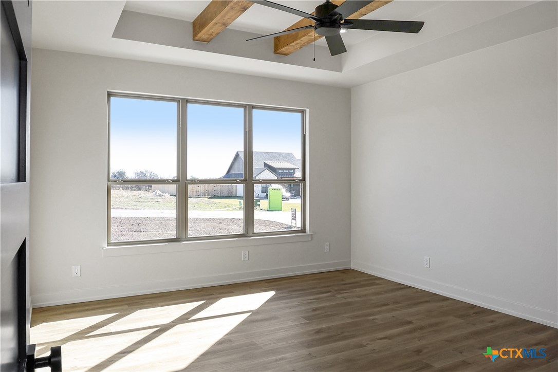 16026 Honey Ridge Drive Holland, TX 76534 - Photo 19 of 27 an empty room with wooden floor fan and windows
