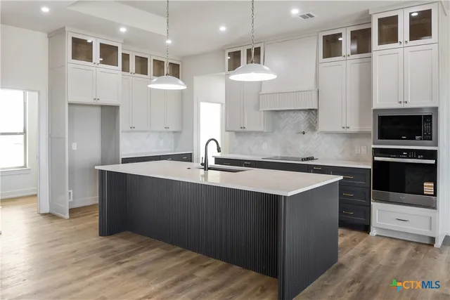 a kitchen with stainless steel appliances granite countertop a sink a stove and a refrigerator