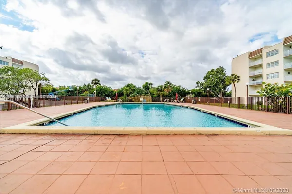 a view of swimming pool with seating area and barbeque oven in the back