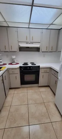 a kitchen with stainless steel appliances granite countertop a sink a stove and white cabinets