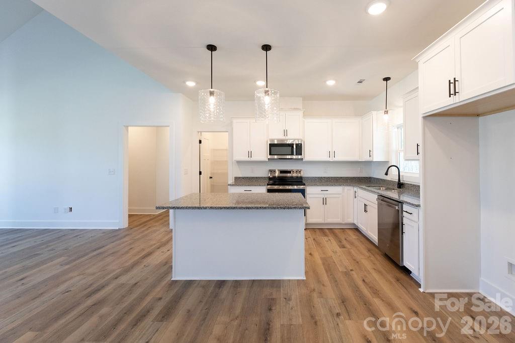 4018 Deerstone Lane Clover, SC 29710 - Photo 6 of 35 a kitchen with stainless steel appliances kitchen island granite countertop a wooden floors and white cabinets