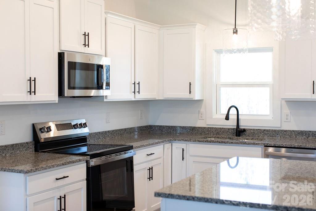 4018 Deerstone Lane Clover, SC 29710 - Photo 8 of 35 a kitchen with stainless steel appliances granite countertop a sink a stove and microwave