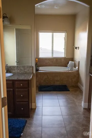 a bathroom with a vanity a mirror and a bathtub