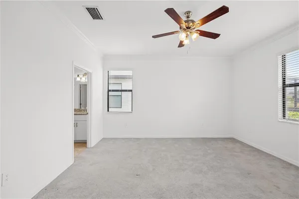 an empty room with a window and a fan