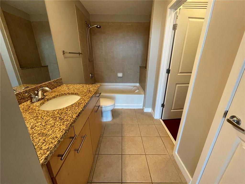 3324 Peachtree Road Northeast, Unit 908 Atlanta, GA 30326 - Photo 11 of 46 a bathroom with a granite countertop sink and a mirror