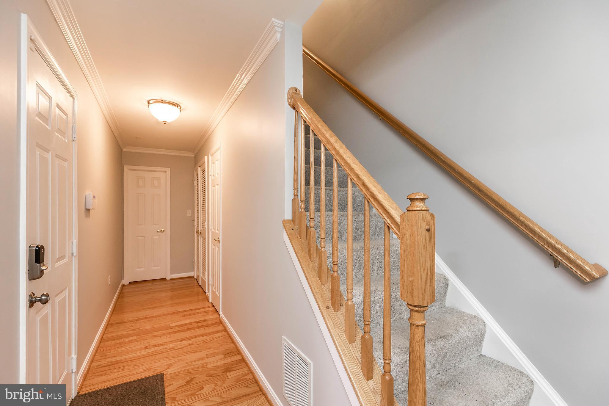 205 Ridgepoint Place Gaithersburg, MD 20878 - Photo 11 of 51 a view of a hallway with wooden floor and staircase