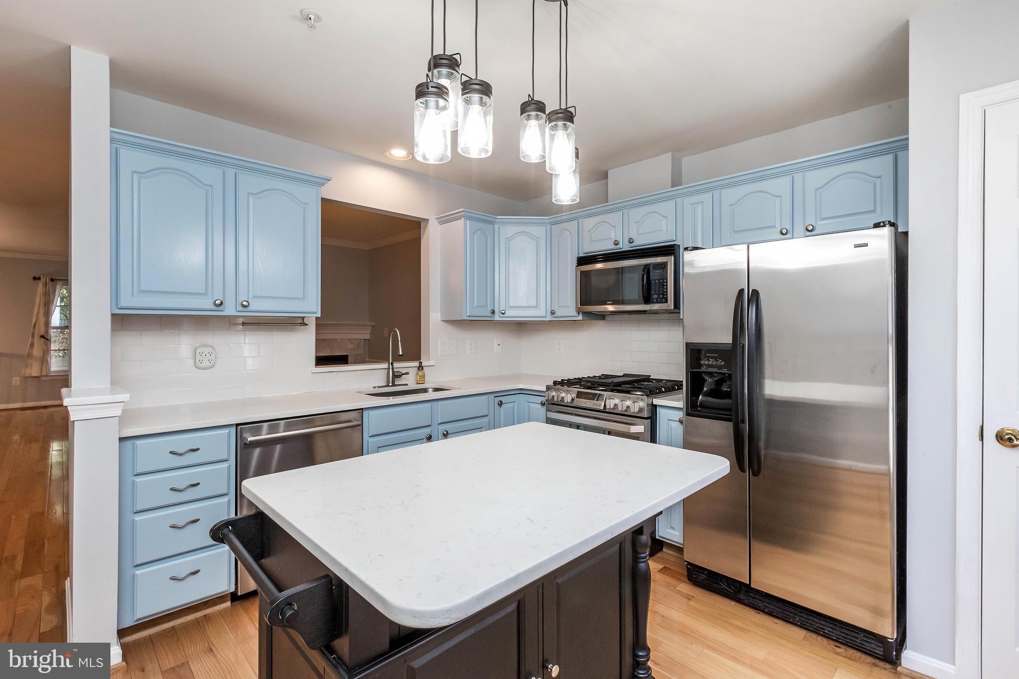 205 Ridgepoint Place Gaithersburg, MD 20878 - Photo 21 of 51 a kitchen with kitchen island a counter space stainless steel appliances and cabinets