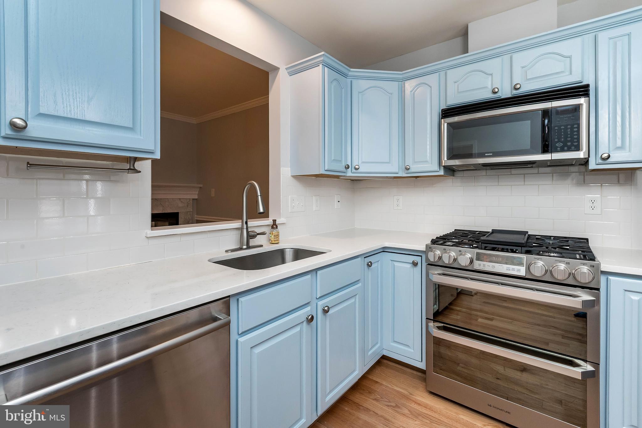 205 Ridgepoint Place Gaithersburg, MD 20878 - Photo 22 of 51 a kitchen with sink a microwave and cabinets