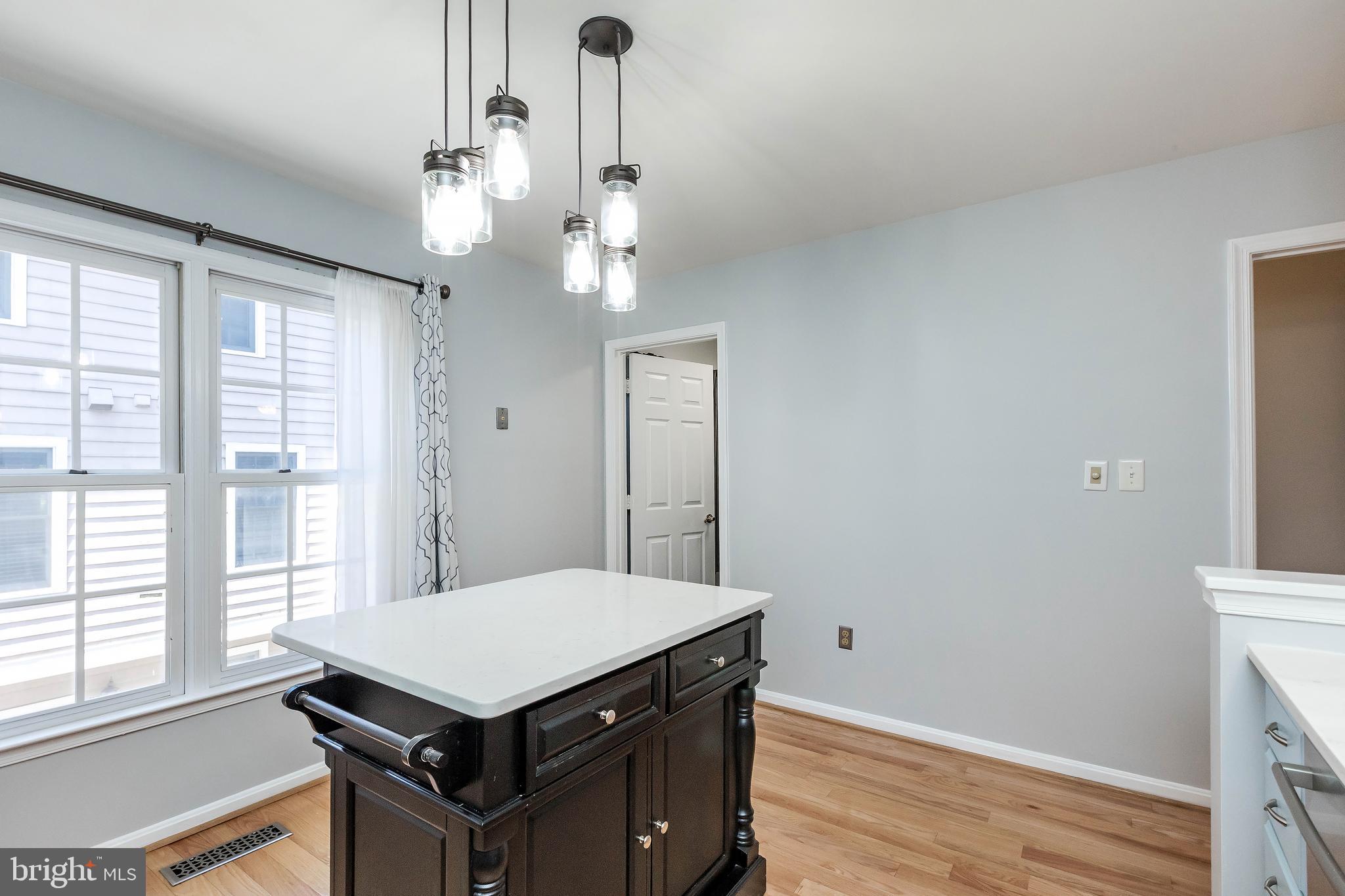 205 Ridgepoint Place Gaithersburg, MD 20878 - Photo 24 of 51 a kitchen that has a table and a chandelier
