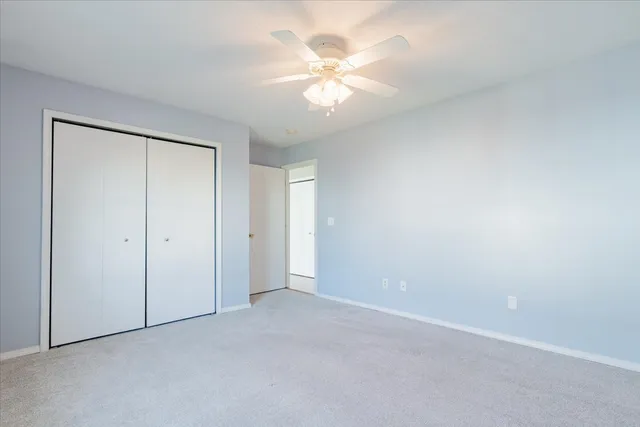 a view of an empty room with a chandelier fan