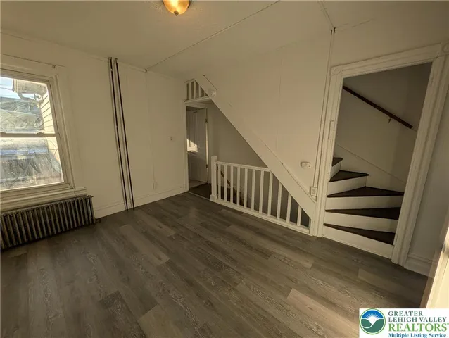 a view of staircase with white walls and wooden floor