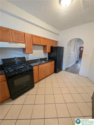 a kitchen with stainless steel appliances a sink dishwasher stove top oven and cabinets