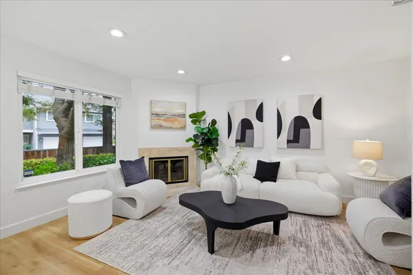 a living room with furniture a table and a large window