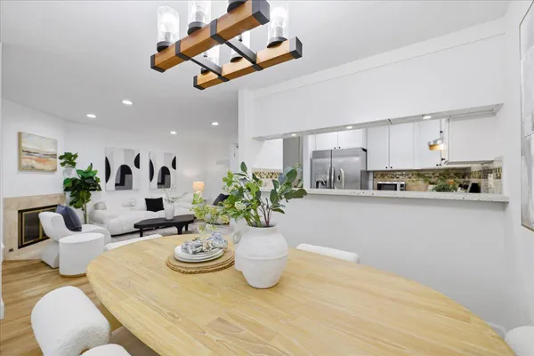a view of a dining room with furniture a chandelier and wooden floor