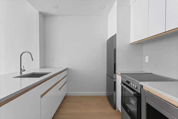 a kitchen with cabinets a sink and a refrigerator