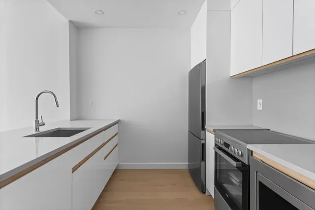 a kitchen with cabinets a sink and a refrigerator