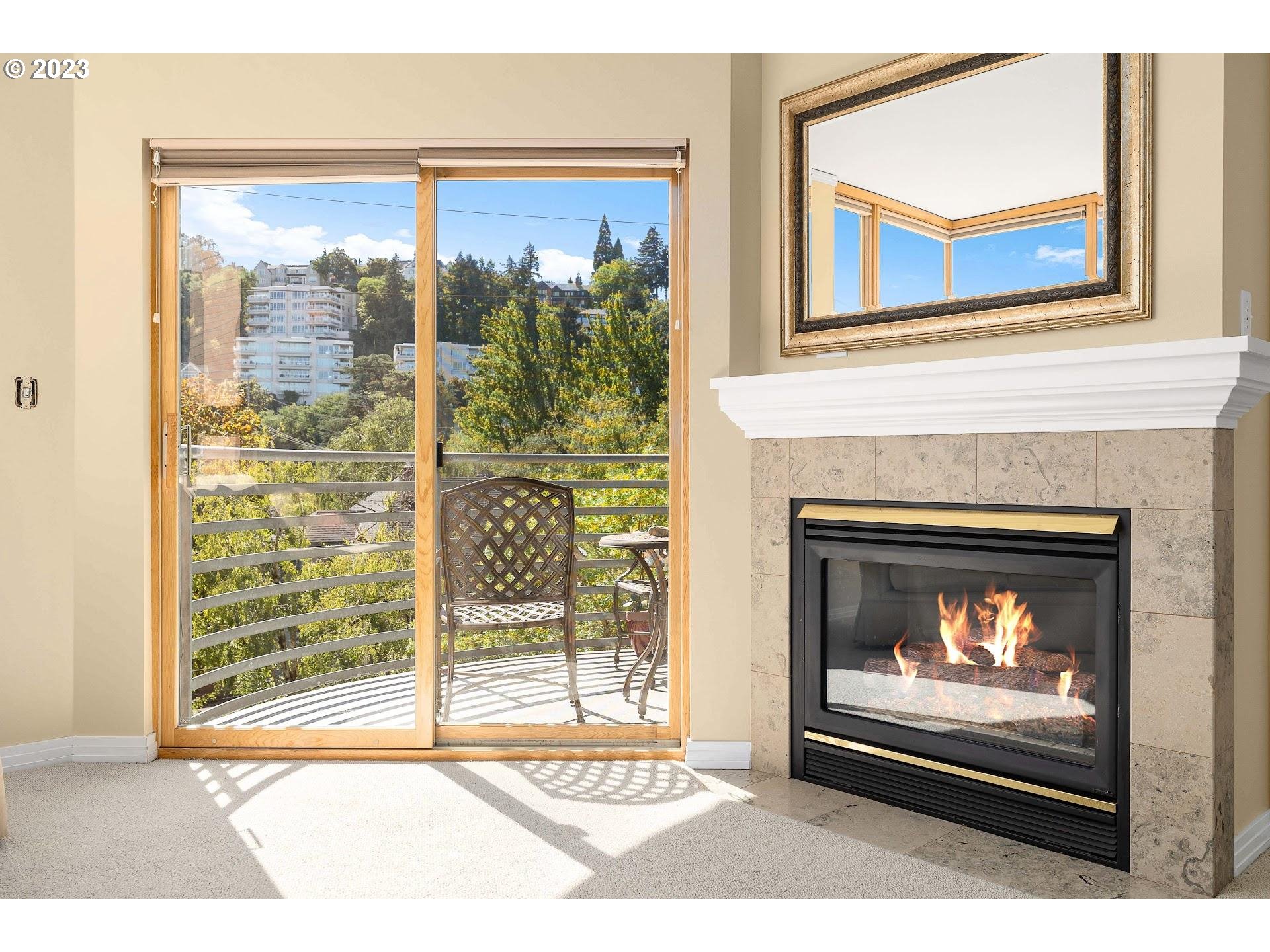 1132 Southwest 19th Avenue, Unit 406 Portland, OR 97205 - Photo 11 of 38 a living room with a fireplace and a floor to ceiling window