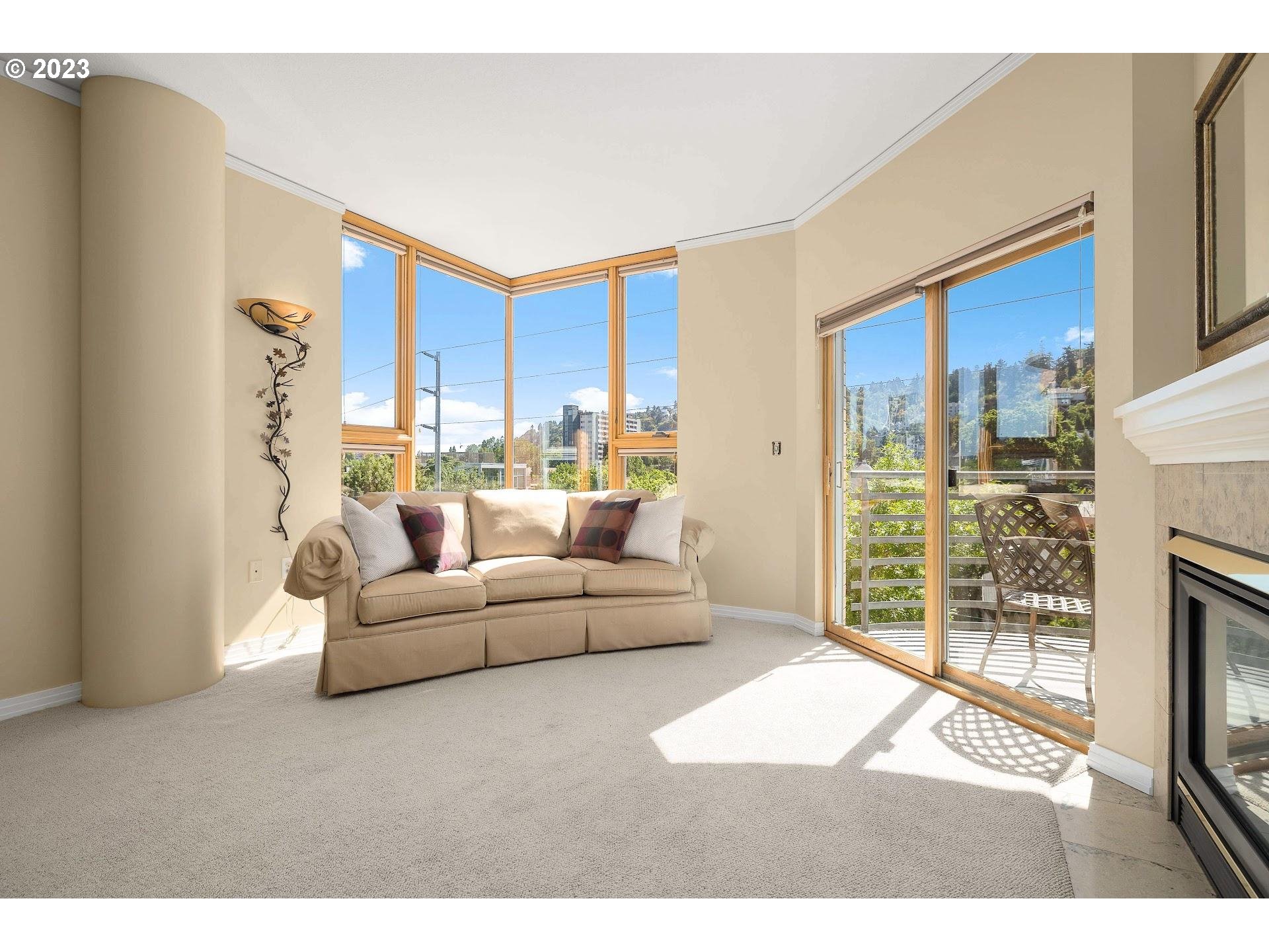 1132 Southwest 19th Avenue, Unit 406 Portland, OR 97205 - Photo 12 of 38 a living room with furniture a floor to ceiling window and a flat screen tv