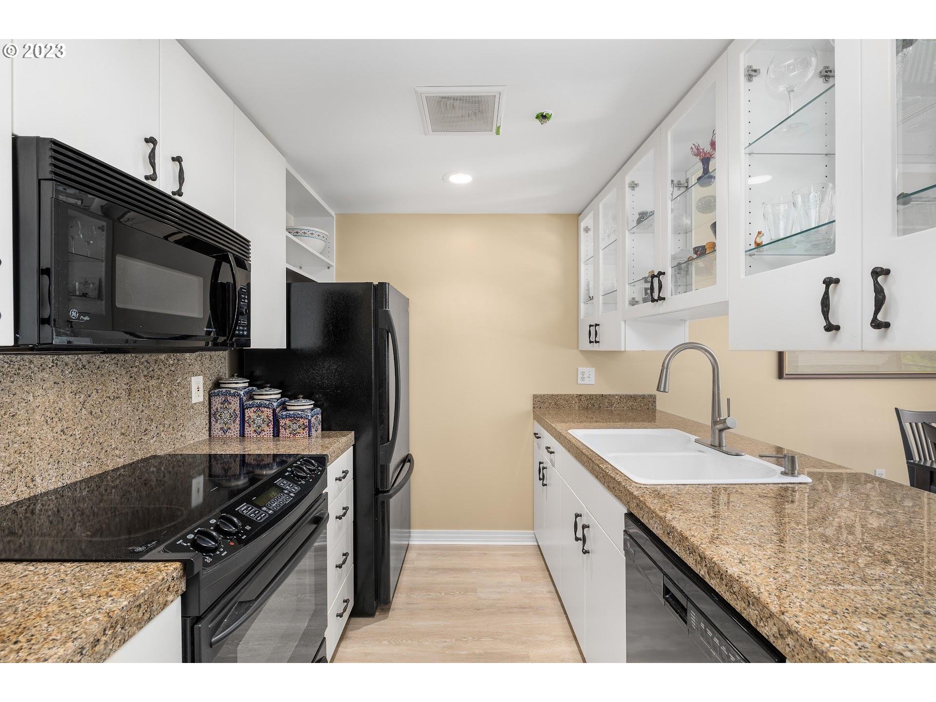 1132 Southwest 19th Avenue, Unit 406 Portland, OR 97205 - Photo 15 of 38 a kitchen with granite countertop stainless steel appliances and sink