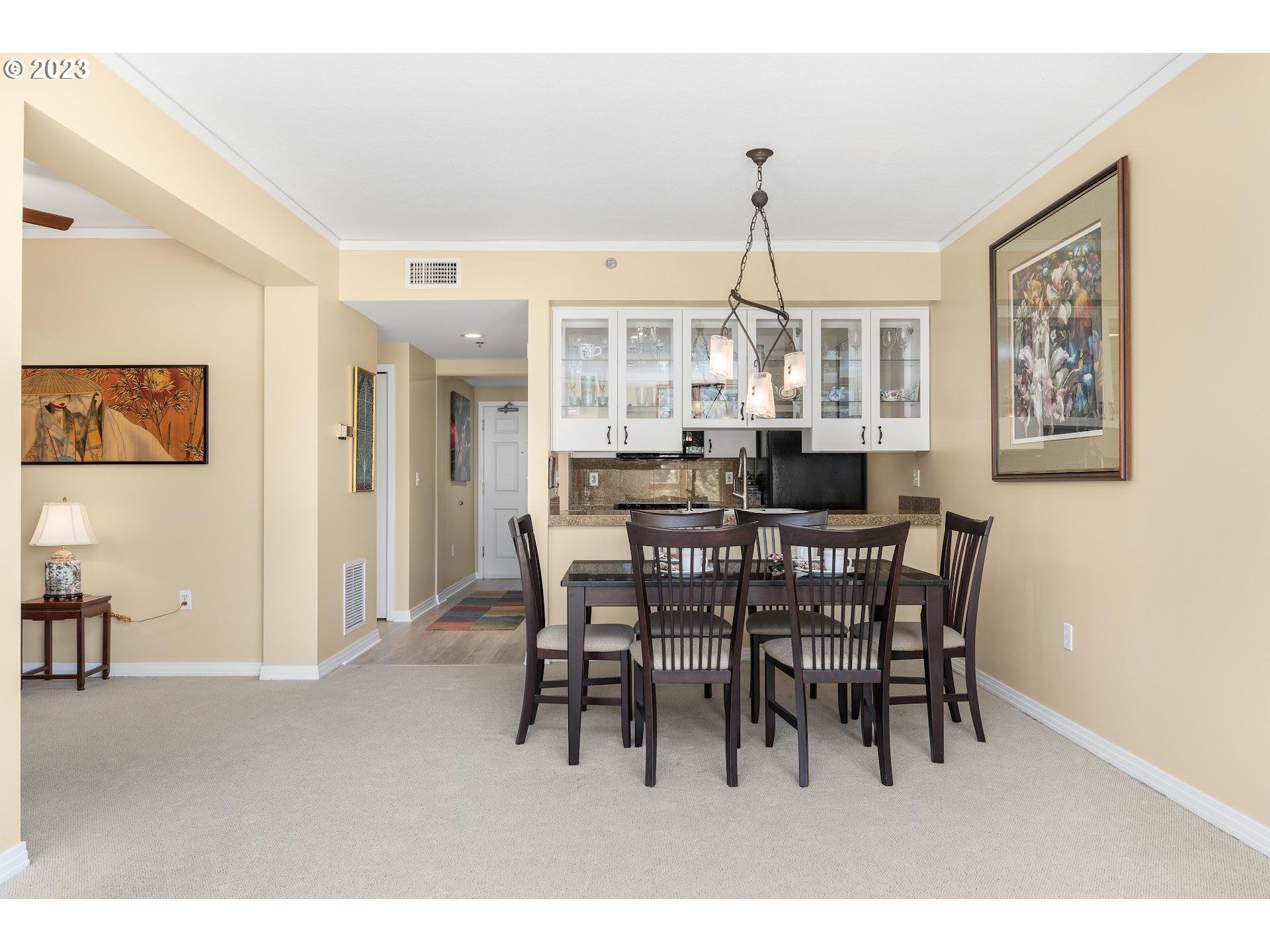 1132 Southwest 19th Avenue, Unit 406 Portland, OR 97205 - Photo 18 of 38 a dining room with furniture a chandelier and window