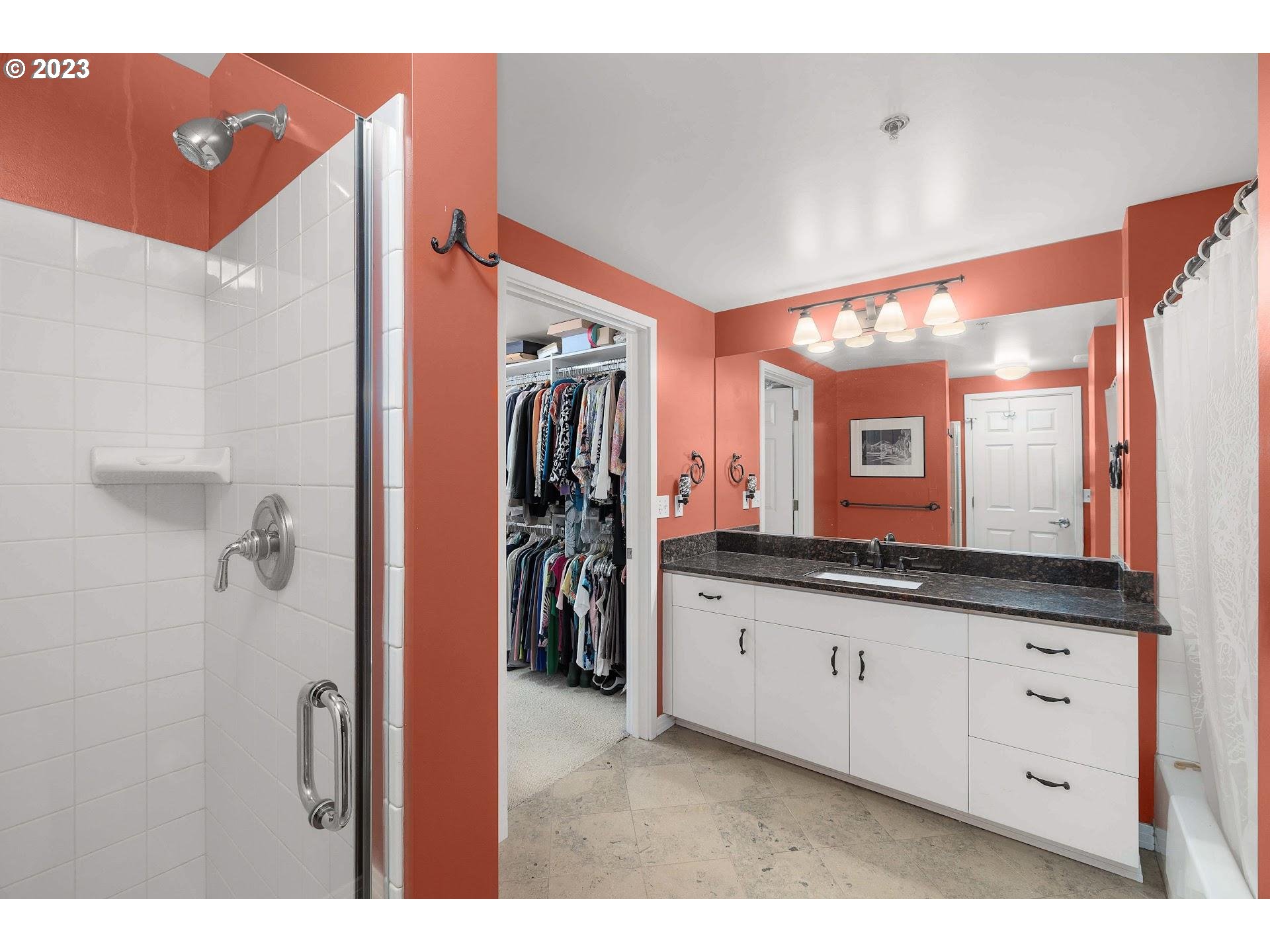 1132 Southwest 19th Avenue, Unit 406 Portland, OR 97205 - Photo 24 of 38 a bathroom with a sink a mirror and a shower