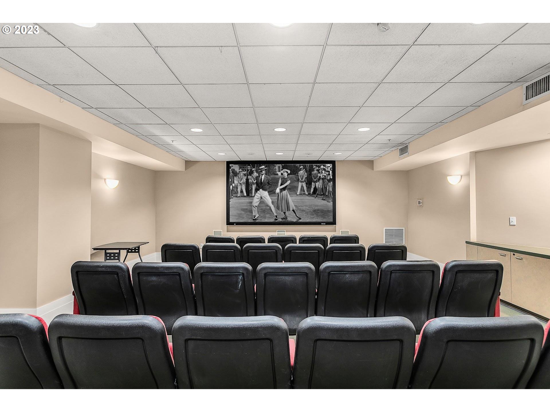 1132 Southwest 19th Avenue, Unit 406 Portland, OR 97205 - Photo 31 of 38 a media room with lots of chairs and a projector screen
