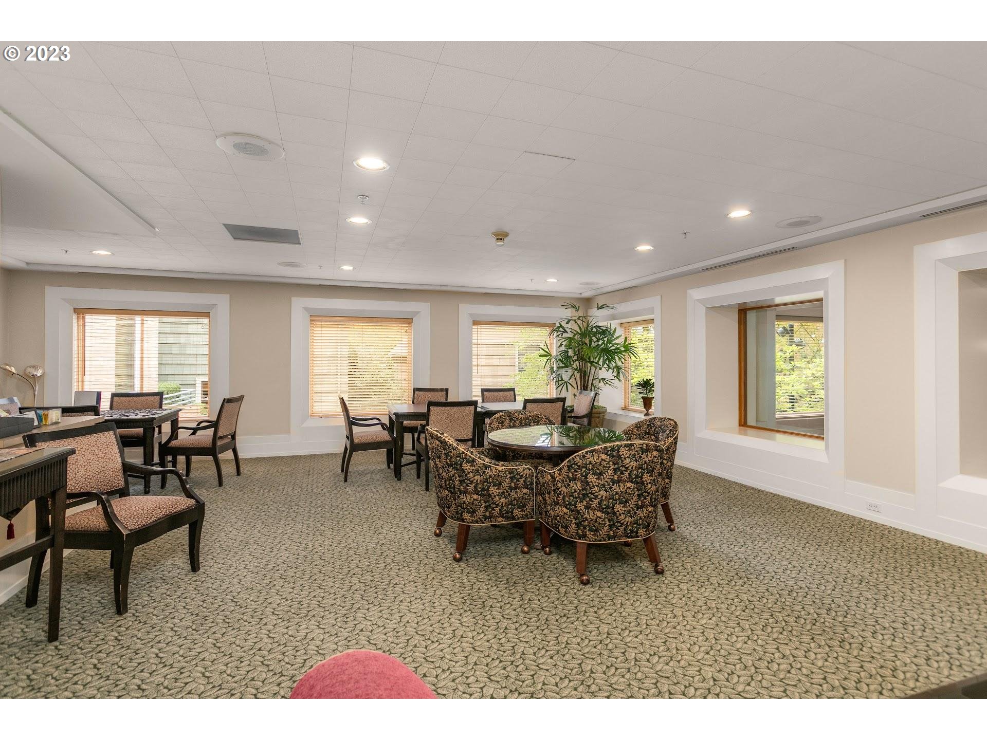 1132 Southwest 19th Avenue, Unit 406 Portland, OR 97205 - Photo 32 of 38 a living room with furniture potted plant and a window