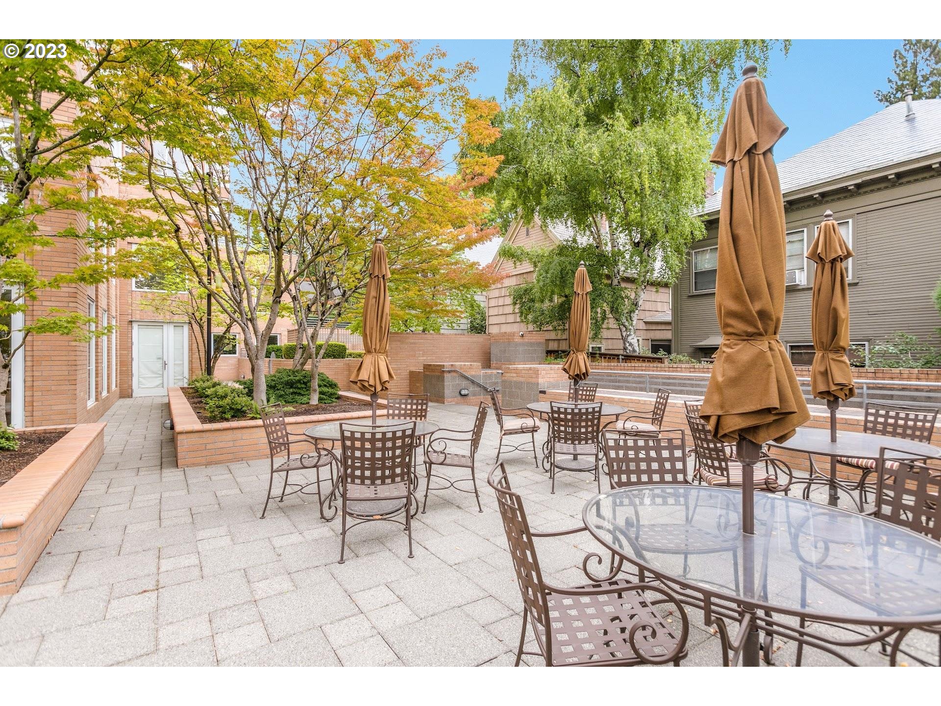 1132 Southwest 19th Avenue, Unit 406 Portland, OR 97205 - Photo 33 of 38 a view of a patio with couches table and chairs and potted plants