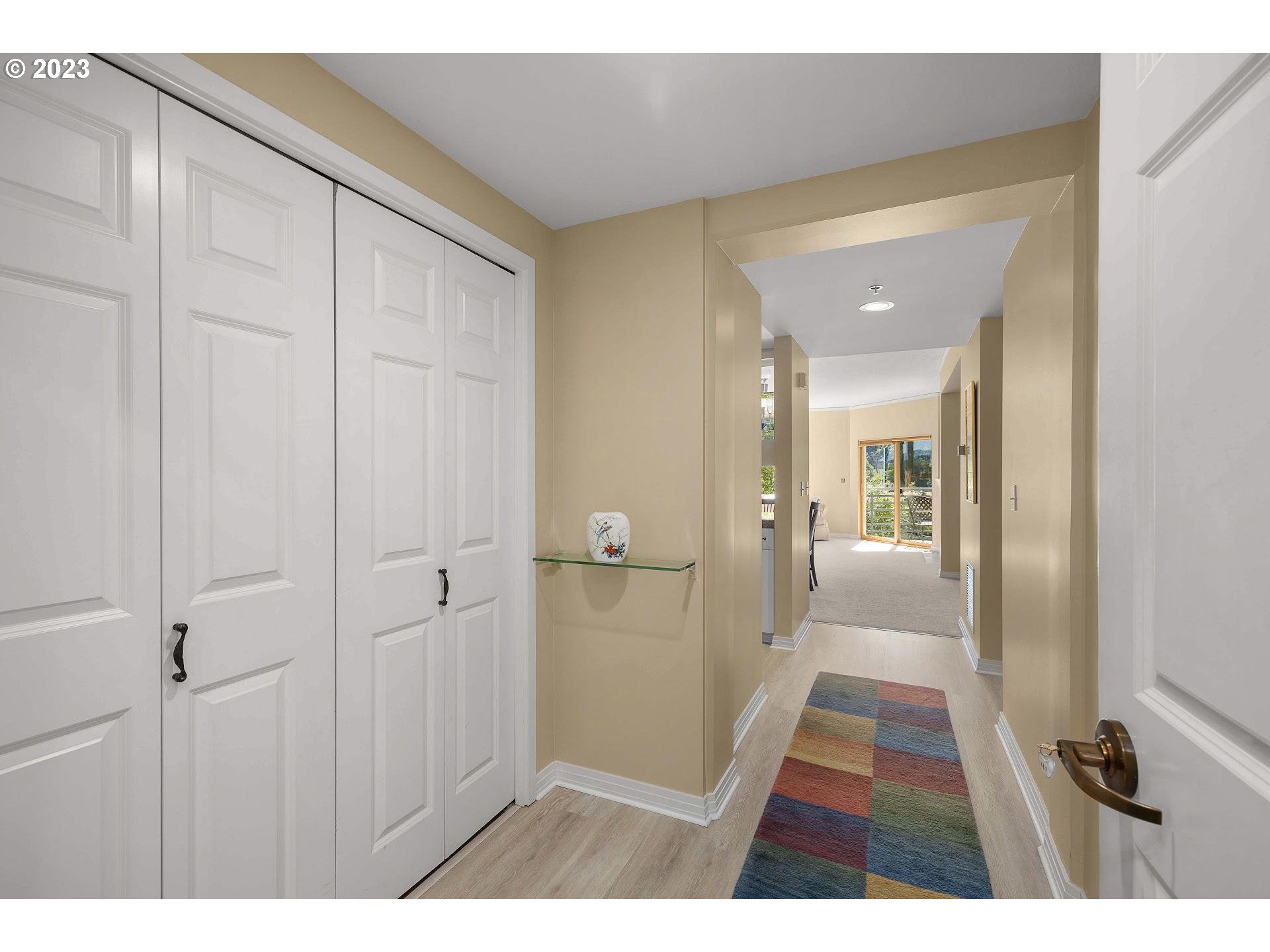 1132 Southwest 19th Avenue, Unit 406 Portland, OR 97205 - Photo 4 of 38 a view of a hallway with wooden floor and a bathroom