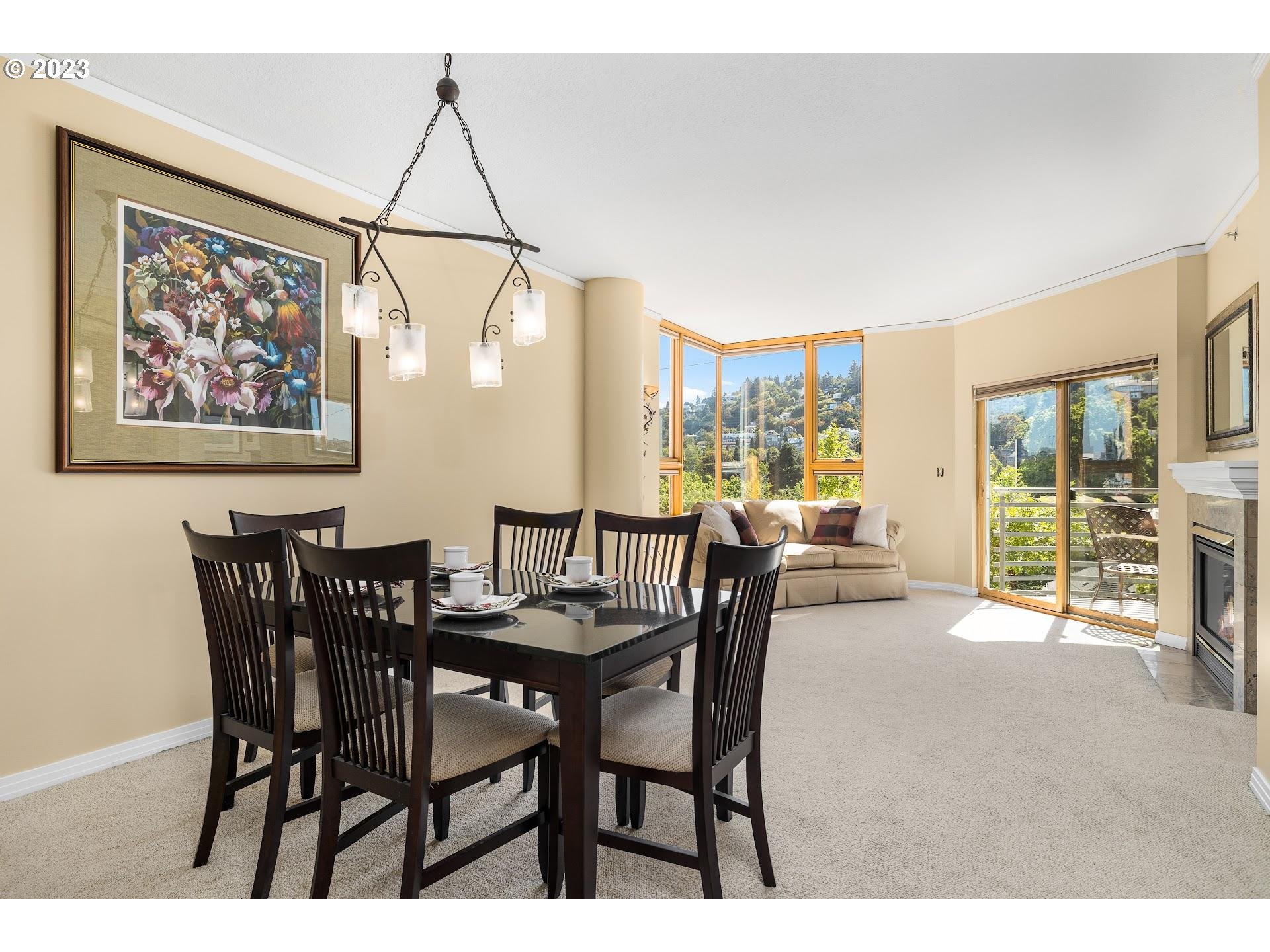 1132 Southwest 19th Avenue, Unit 406 Portland, OR 97205 - Photo 5 of 38 a view of a dining room with furniture large windows and wooden floor