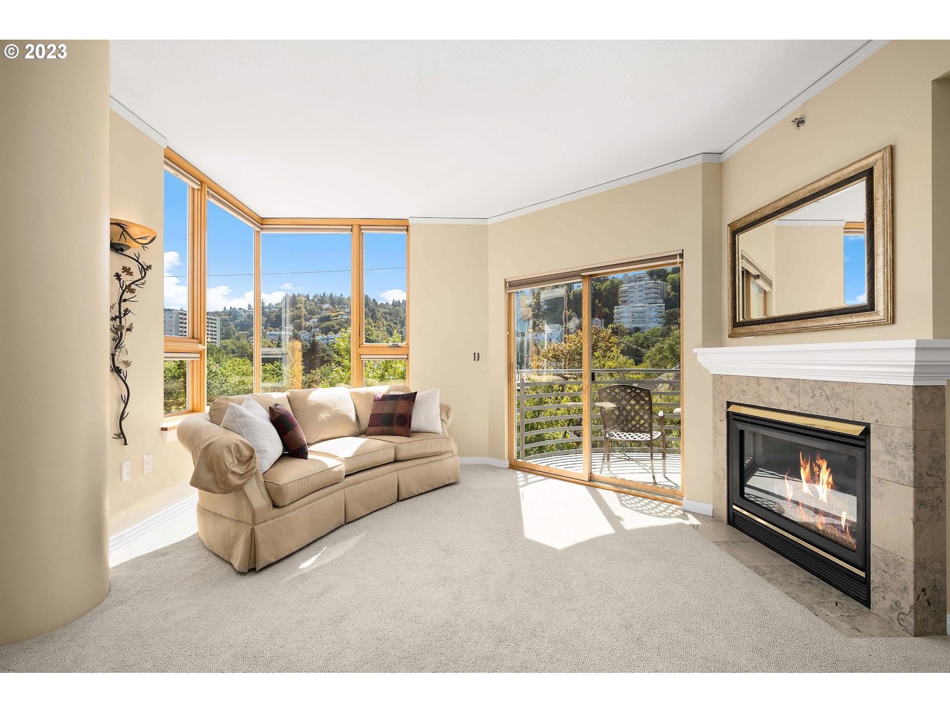 1132 Southwest 19th Avenue, Unit 406 Portland, OR 97205 - Photo 9 of 38 a living room with furniture a floor to ceiling window and a fireplace