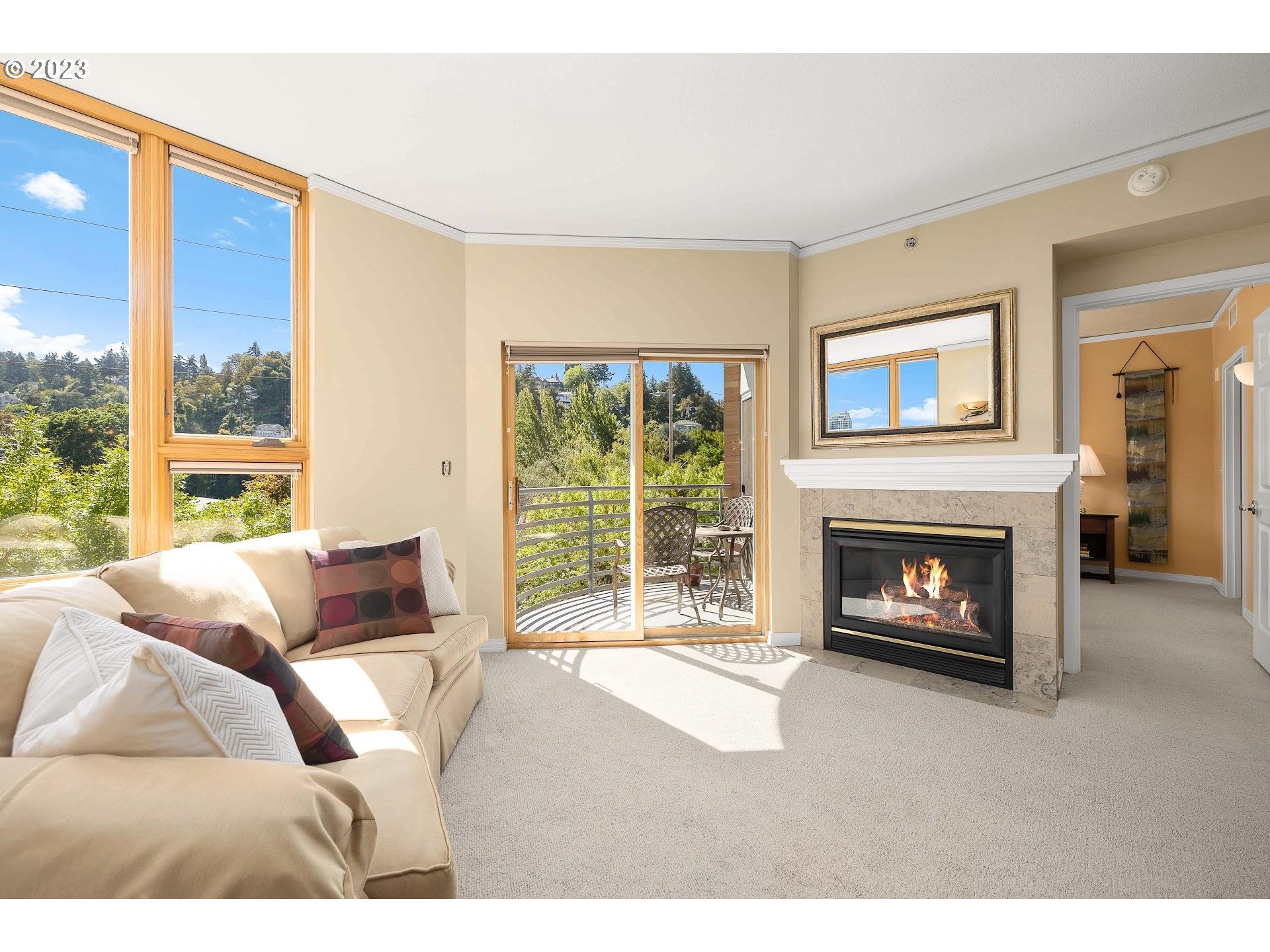 1132 Southwest 19th Avenue, Unit 406 Portland, OR 97205 - Photo 10 of 38 a living room with furniture a fireplace and a large window