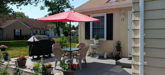 a patio with a table and chairs under an umbrella