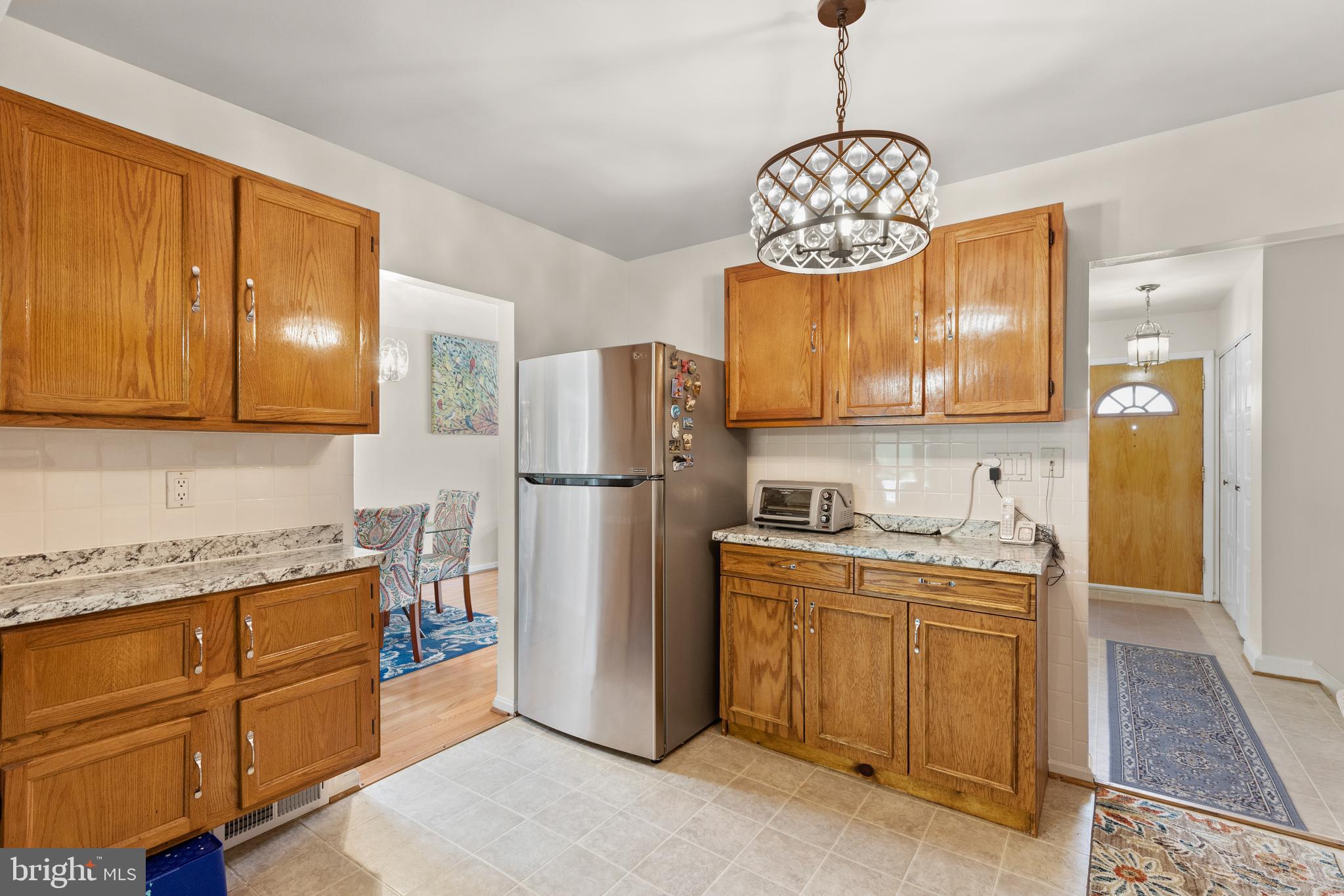 12401 Barbara Road Silver Spring, MD 20906 - Photo 8 of 17 a kitchen with stainless steel appliances granite countertop a refrigerator a sink dishwasher and wooden cabinets with wooden floor