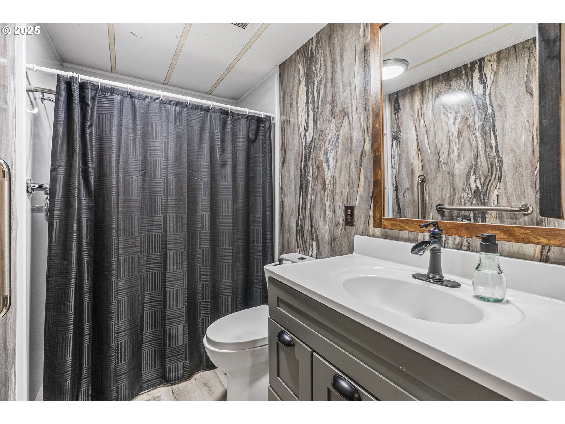 2032 Southeast 283rd Avenue Camas, WA 98607 - Photo 11 of 22 a bathroom with a sink a toilet a mirror and shower curtain