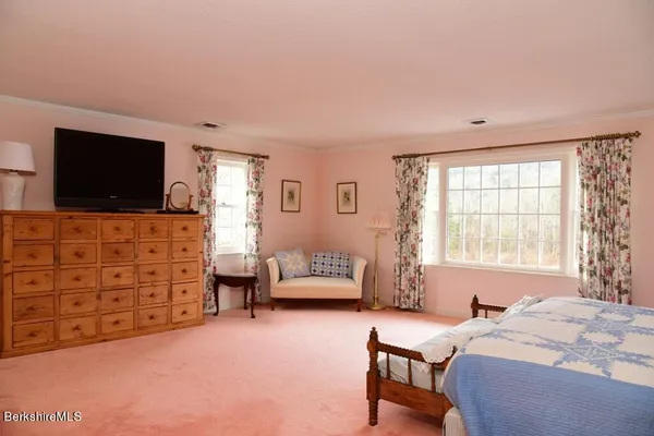 a bedroom with a bed a lamp and a large window