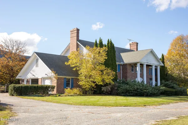 a front view of a house with a yard and potted plants