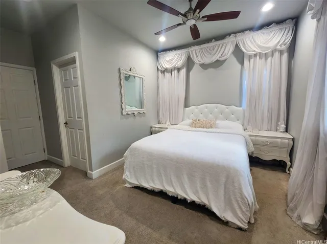 a bed sitting in a room next to a curtain and a window