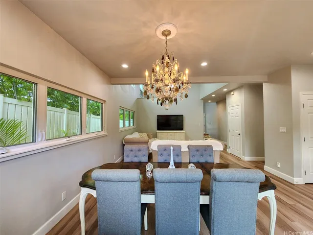 a view of a dining room with furniture a chandelier and wooden floor