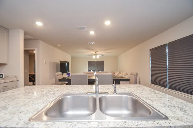 a kitchen with kitchen island a sink and a large window