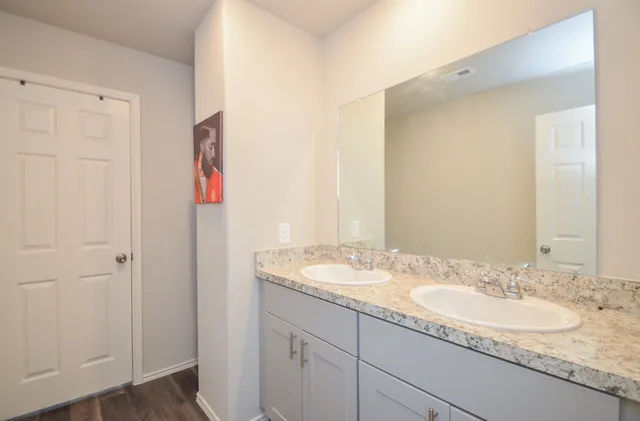 a bathroom with a granite countertop sink and a mirror