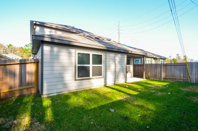 a view of a yard with wooden fence and a large tree
