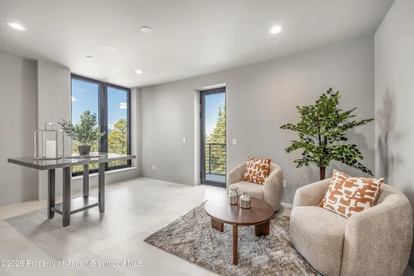 a bedroom with a balcony a bed and a large window
