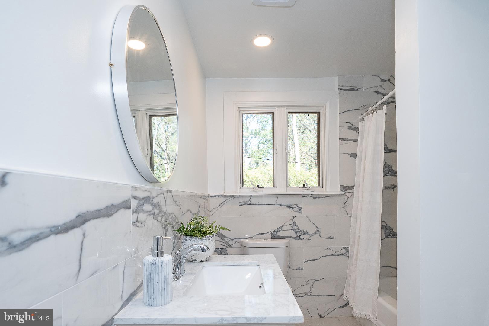 875 Old State Road Berwyn, PA 19312 - Photo 22 of 30 a bathroom with a bathtub sink and mirror