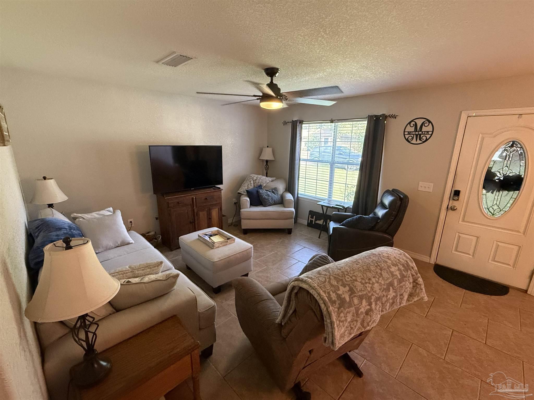 4221 Jernigan Road Pace, FL 32571 - Photo 2 of 11 a living room with furniture and a flat screen tv