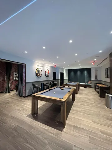 a living room with stainless steel appliances kitchen island furniture and a flat screen tv