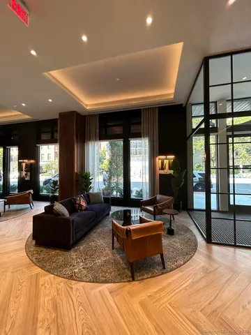 a living room with furniture large window and flat screen tv