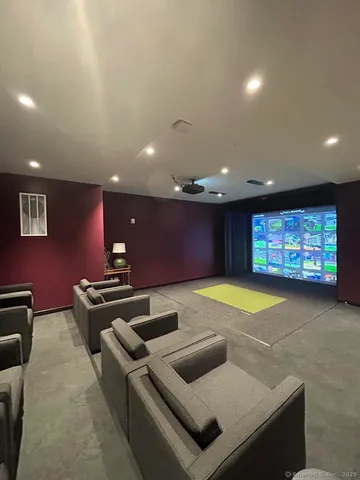 a projector room with pool table a projector with a large screen and couches