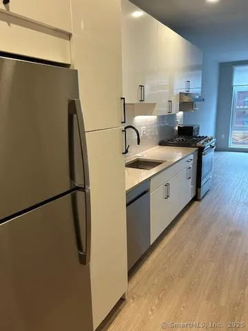 a kitchen with stainless steel appliances granite countertop a stove a sink and a refrigerator