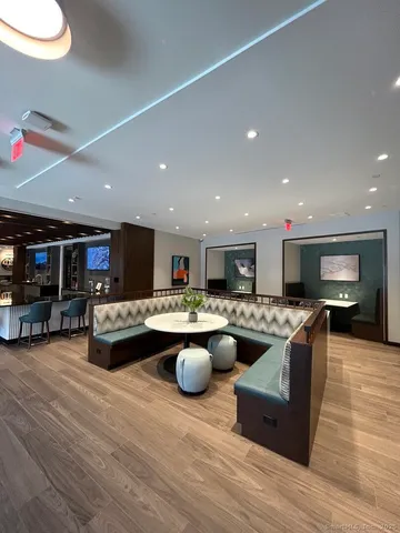 a living room with furniture a flat screen tv and kitchen view